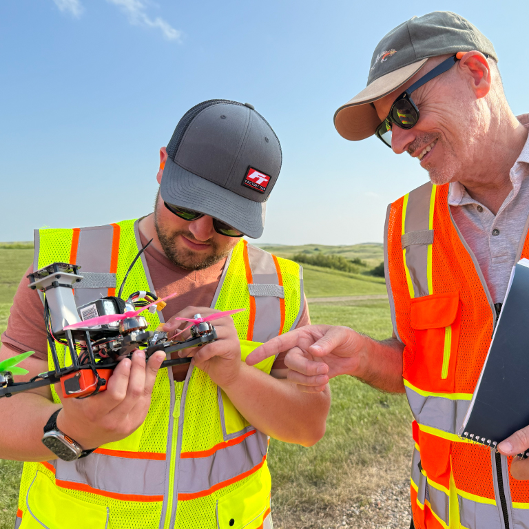 Two men inspecting a small unmanned vehicle