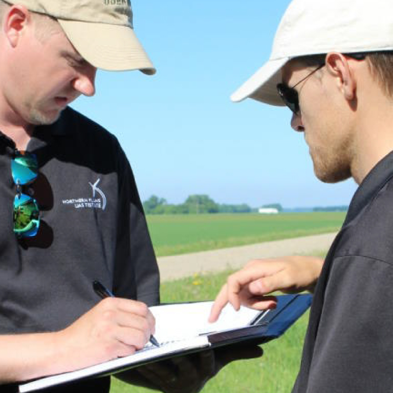 Two men looking at a notepad