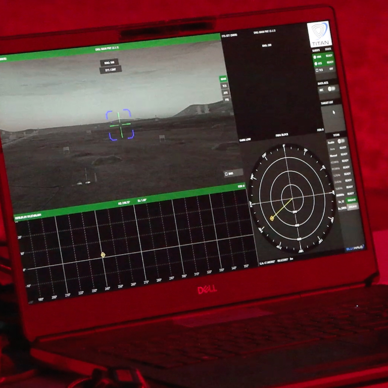 A laptop showing a view from an unmanned vehicle, with a deep, red overlay