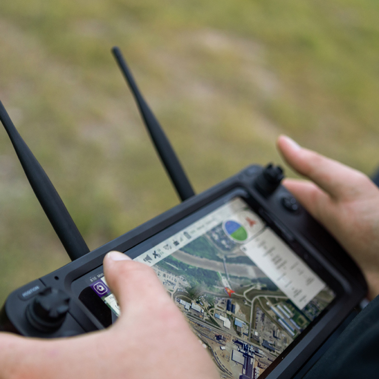 A person operating a tablet showing an aerial map view