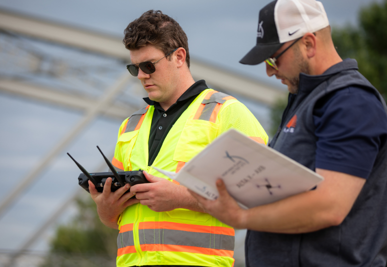 A man in high-visibility vest controlling an unmanned vehicle with a controller