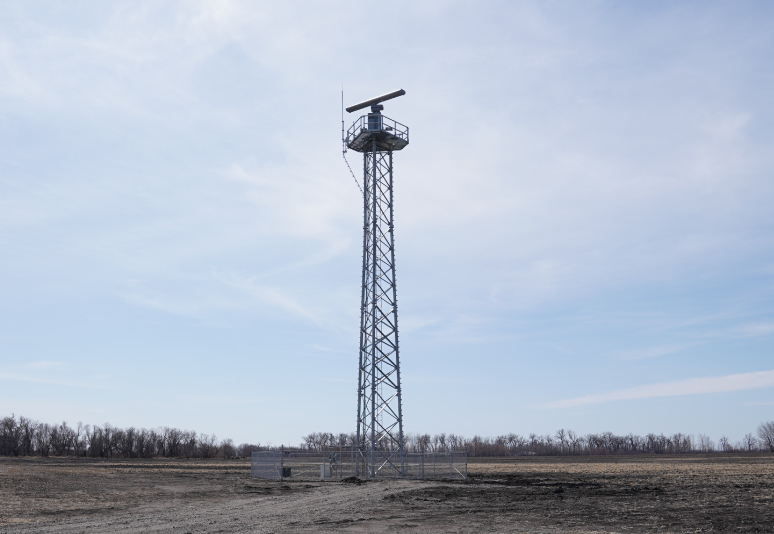 A tall radar in a barren field